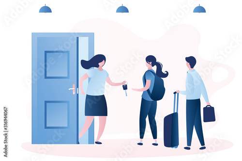  Man and woman with luggage stand near open door and taking key from home owner.