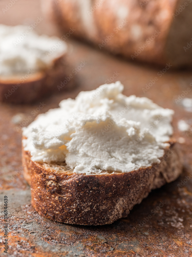 Whole grain bread bruschetta with white soft curd cream cheese on a ginger grunge background. Close-up Whole grain bread bruschetta with white soft curd cream cheese on a ginger grunge background. Close-up