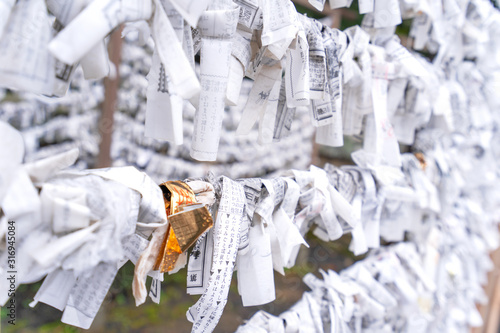 Obraz na plátně Japanese random fortune telling paper (Omikuji) folded and tied on rope wires (Omikuji kake) in traditional temple, concept of bringing blessing