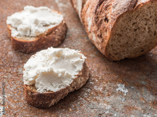 Whole grain bread bruschetta with white soft curd cream cheese on a ginger grunge background. Close-up