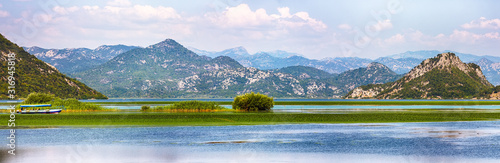 Awesome view of Skadar lake surrounded by green mountain peaks on a sunny day.