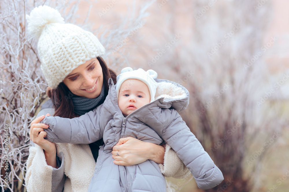 Obraz premium Mother Taking Baby Out for a Walk in Winter