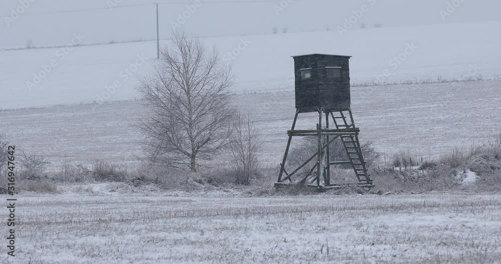 Winter european landscape with hunting tower covered with snow and heavy snowfall storm with falling snowflakes. Christmas concept. Winter european landscape with hunting tower covered with snow and heavy snowfall storm with falling snowflakes. Christmas concept.