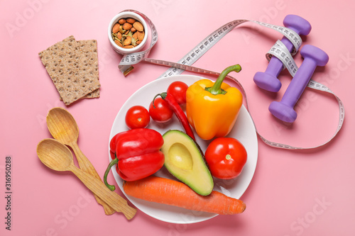 Different healthy food with measuring tape and dumbbells on color background. Diet concept