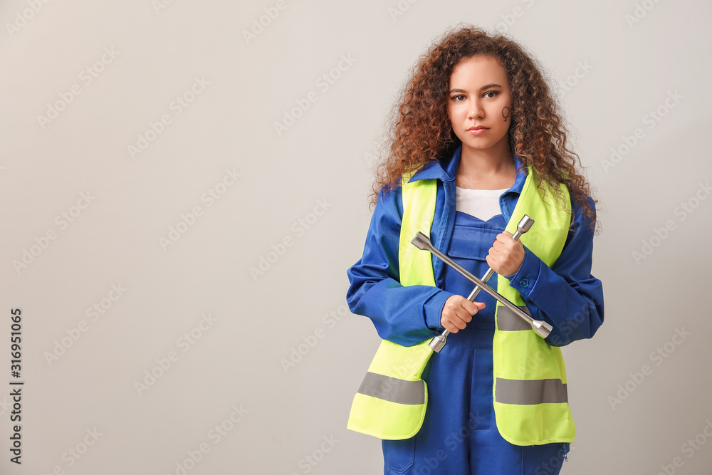 Female worker on light background. Concept of feminism Female worker on light background. Concept of feminism