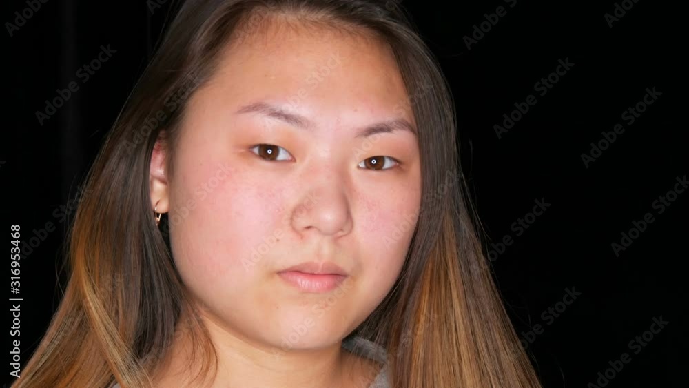 Portrait of a beautiful Asian girl model without makeup who poses in a professional studio Portrait of a beautiful Asian girl model without makeup who poses in a professional studio