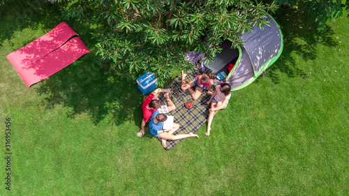 Family vacation in campsite aerial top view from above, parents and kids relax and have fun in park, tent and camping equipment under tree, family in camp outdoors concept 