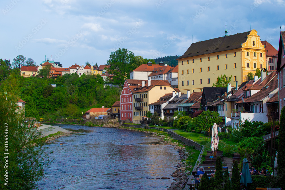 View of traditional czech houses and Vltava river with green trees and vegetation, in Cesky Krumlov, Czech Republic