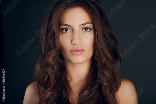 Portrait of beautiful young brunette woman with healthy fluffy hair