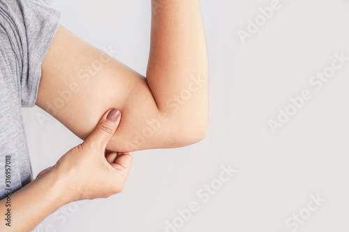 closeup woman hand holding fat on her arm