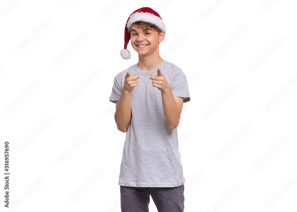 Christmas teen boy in Santa Hat pointing finger at camera. Cute smiling child in Santa red hat choose you, isolated on white background. Winter holidays. Happy xmas and New Year. Christmas teen boy in Santa Hat pointing finger at camera. Cute smiling child in Santa red hat choose you, isolated on white background. Winter holidays. Happy xmas and New Year.