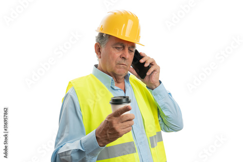 Builder talking on phone and holding coffee cup