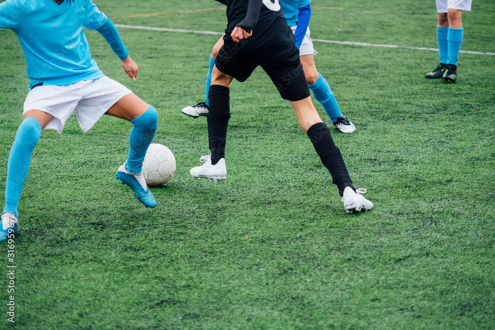 Unrecognizable male soccer players playing a game on the soccer field. Unrecognizable male soccer players playing a game on the soccer field.