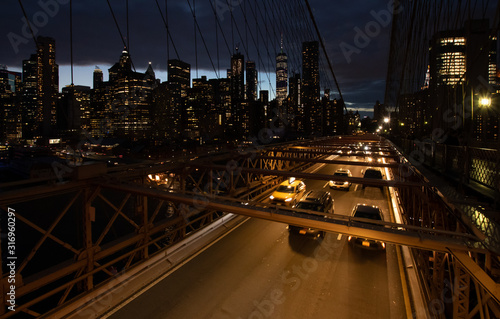Cars speeding at night on Brooklyn Bridge, Manhattan. One of the most iconic bridges in the world, a must see attraction when visiting New York.