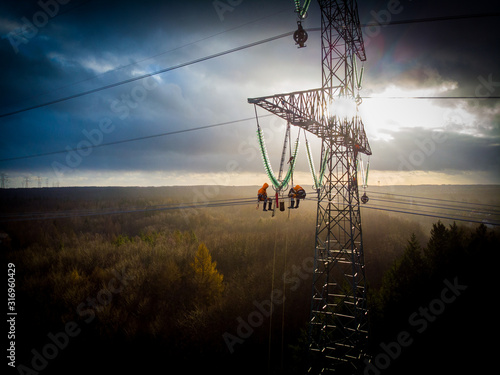 POMERANIA DISTRICT,POLAND - DECEMBER 8,2018:  Aerial view of electricians working on electric poles to install and repair power lines.