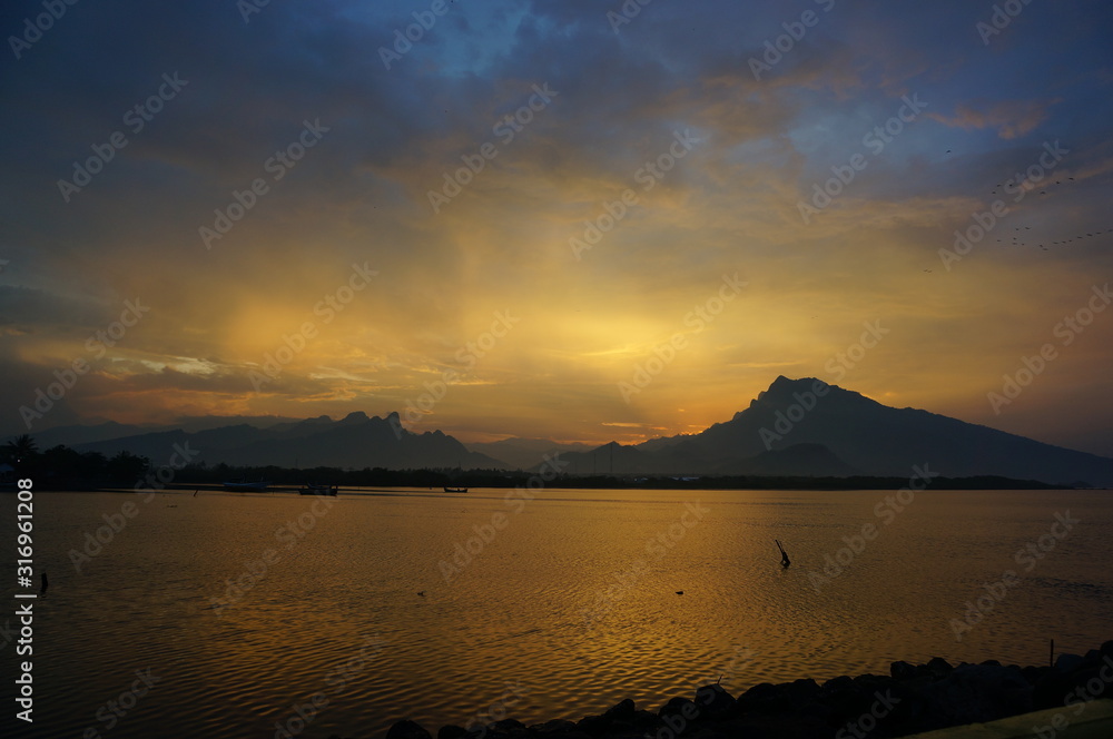 sunset and sunrise on the beach with a mountain backdrop sunset and sunrise on the beach with a mountain backdrop