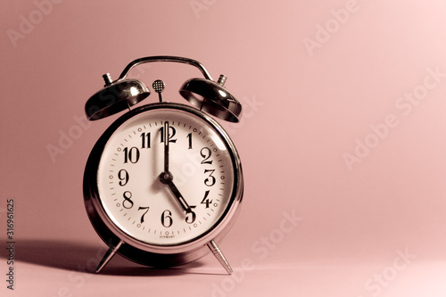 Vintage alarm clock on a solid color background