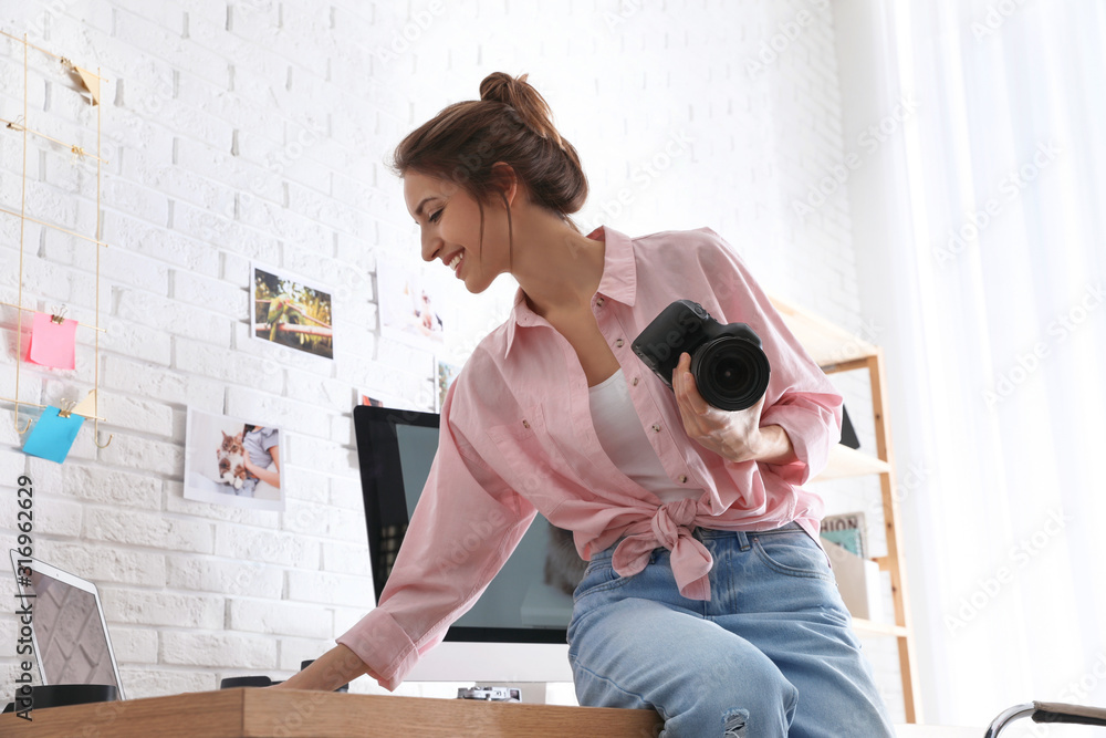 Professional photographer with camera working in light modern office Professional photographer with camera working in light modern office