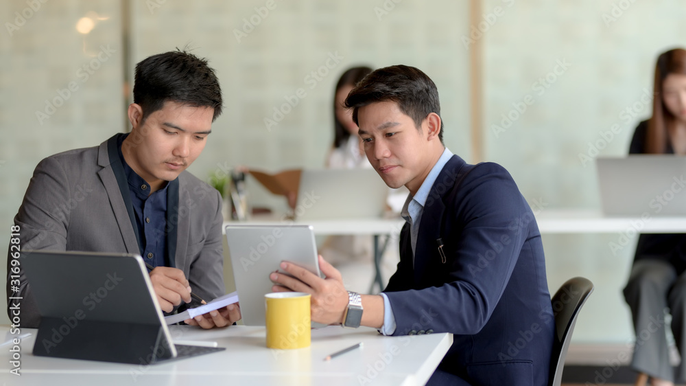 Close up view of two of businessman discussing on their task in modern co working space room