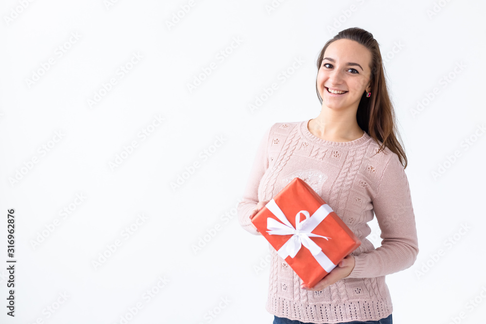Holidays, valentine's day and festive concept - Beautiful smiling woman with long hair holding gift box. White background isolated studio portrait, copyspace Holidays, valentine's day and festive concept - Beautiful smiling woman with long hair holding gift box. White background isolated studio portrait, copyspace