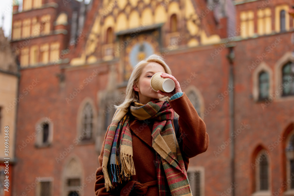 Beautiful blonde woman drink a coffee in old town