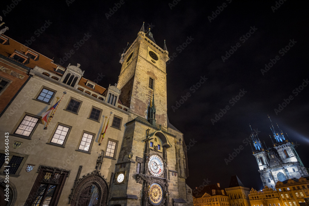 Fototapeta premium Old Town Square (Staromestske namesti) of Prague, Czech Republic, at night, with the Old Town hall in front (Staromestska Radnice) and its astronomical clock and the Cathedral in background