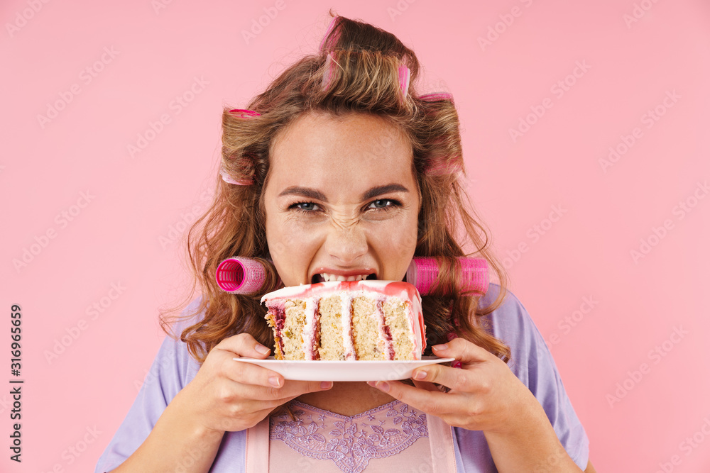 Image of young happy woman looking at camera and eating cake Image of young happy woman looking at camera and eating cake