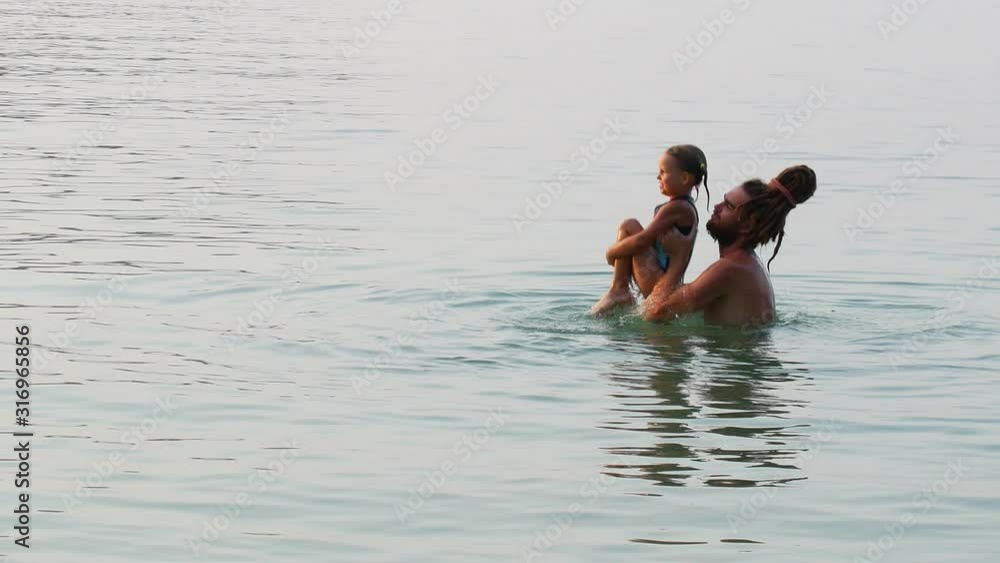 Father and daughter are playing at sea. Father and daughter are playing at sea.