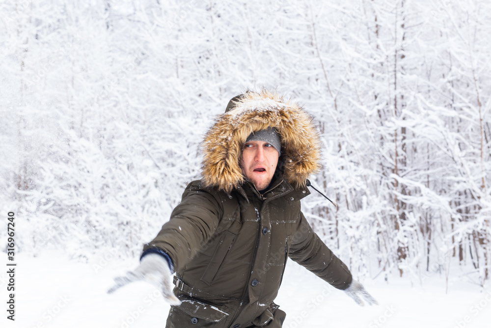 Handsome man in winter hat funny portrait on snowy nature Handsome man in winter hat funny portrait on snowy nature