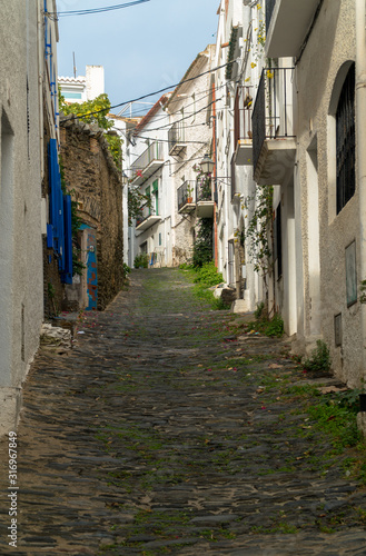 Cadaqu  s  Catalonia   Spain - November 30th  2019  Old narrow cobbled street in the old village center
