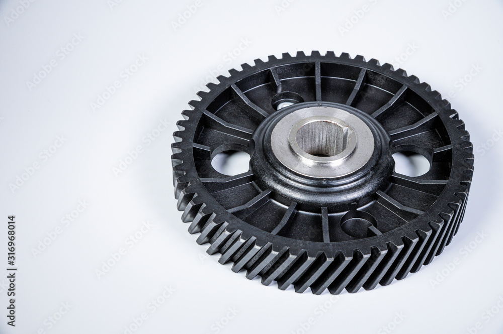 Black polymer gear camshaft with metal base. New spare part for an internal combustion engine on a gray background Black polymer gear camshaft with metal base. New spare part for an internal combustion engine on a gray background
