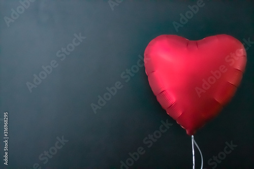 Red air balloons in the shape of a heart on a black background. valentines day, love.