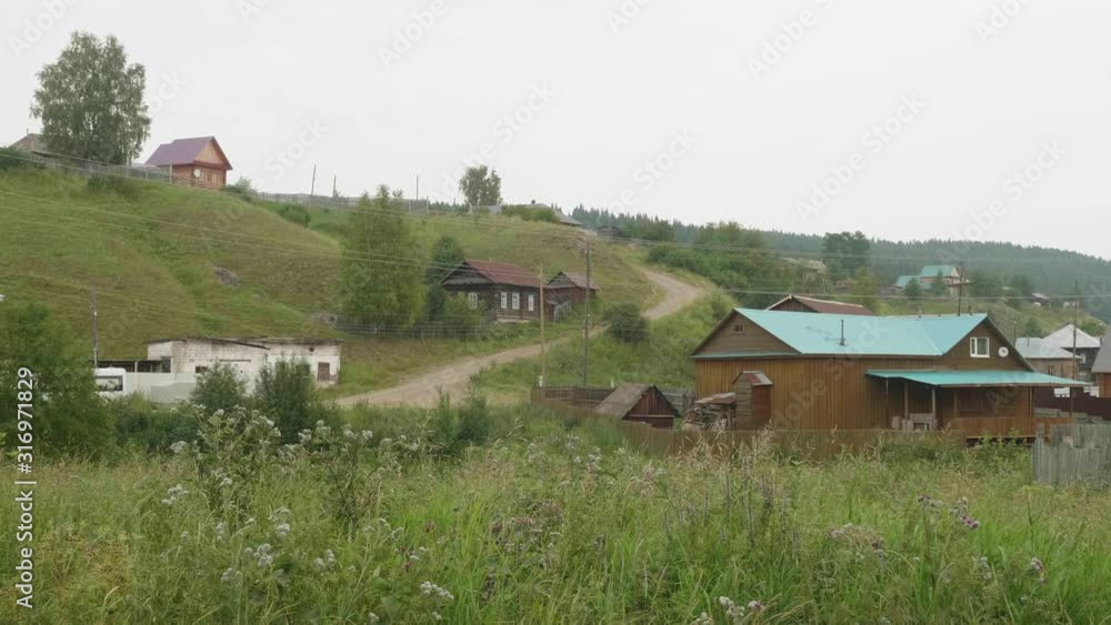 Old russian village with its old wooden houses, countryside roads and green juicy grass on banks of small river. Old russian village with its old wooden houses, countryside roads and green juicy grass on banks of small river.