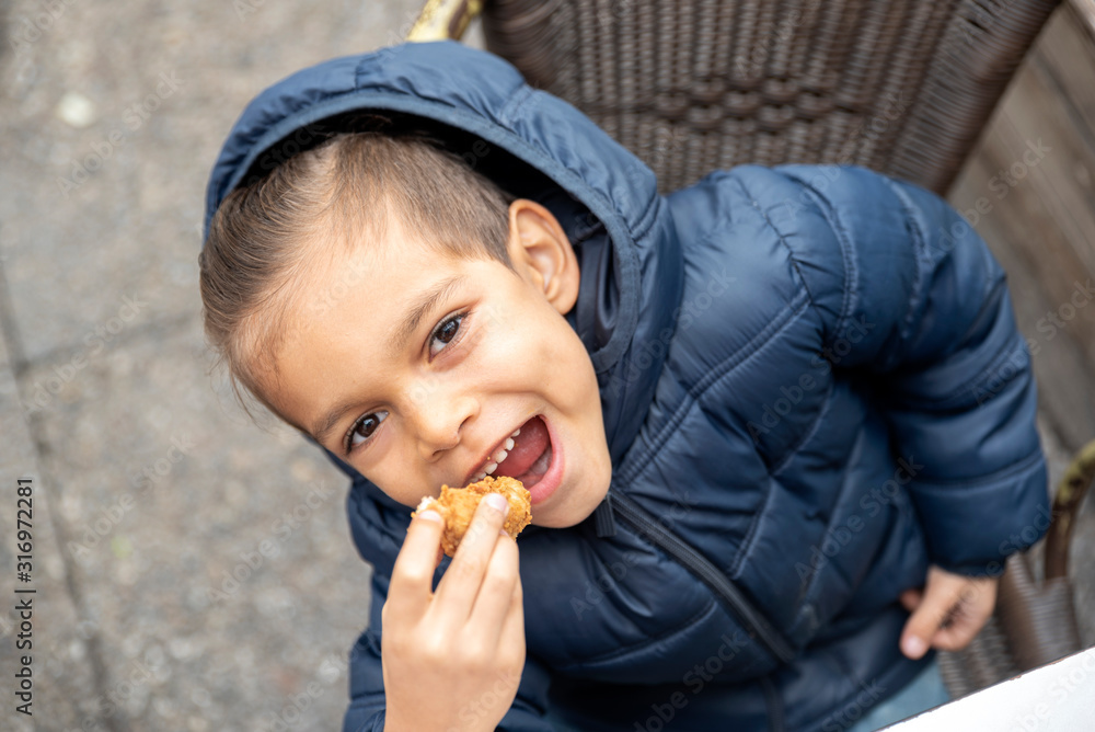 little boy eats fried chicken