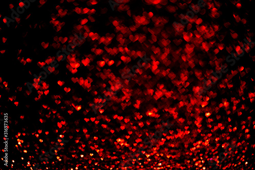 Abstract light, red bokeh pattern in heart shape on black. St Valentines Day or Holiday concept, background image.