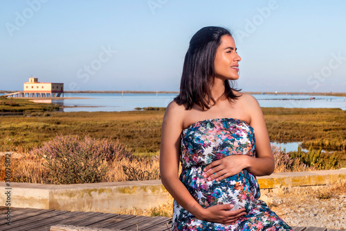 Pregnant woman poses on the marshlands. photo