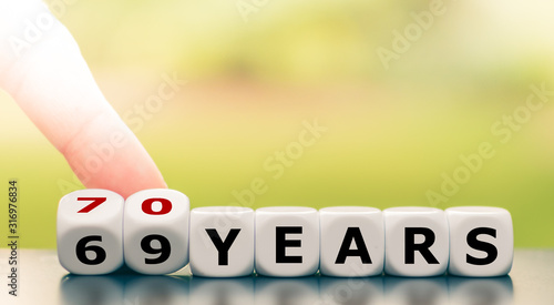 Photography Hand turns dice and changes the expression 69 years to 70 years