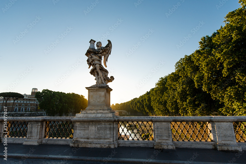 Sculpture of an angel on the famous bridge over the Tiber river at the castle of San Angelo in Rome, the capital of Italy, early in the morning at dawn