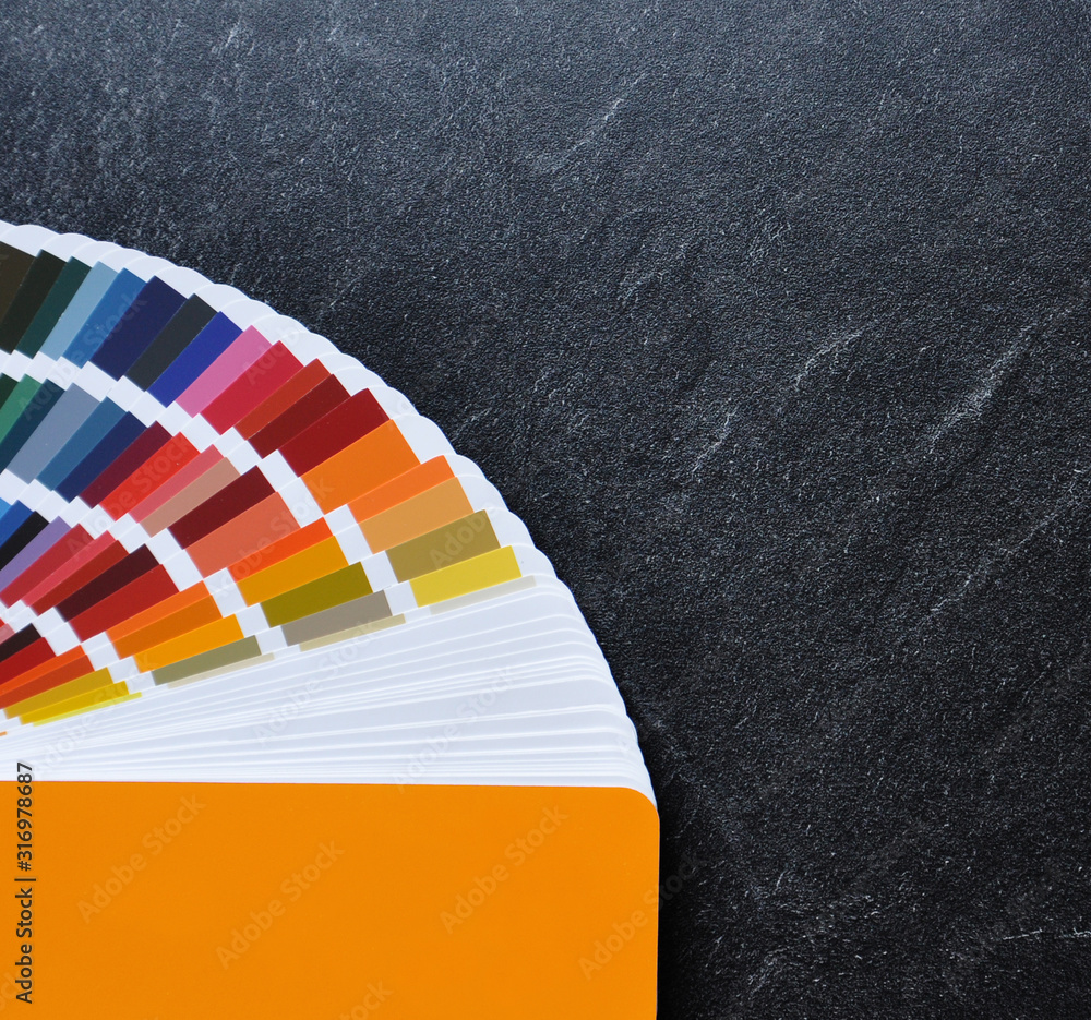 Color palette guide, fan, catalogue on black background. Ral color fan with  orange cover on stone texture Stock Photo | Adobe Stock