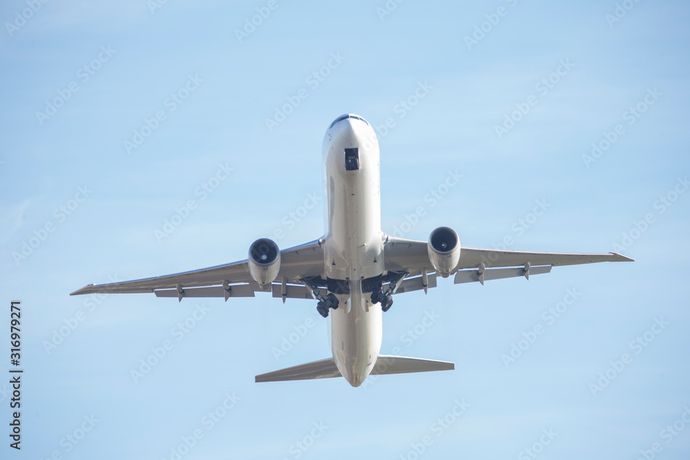 Passenger plane flying seen from below.