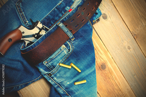 fashion old blue jeans and vintage revolver photo