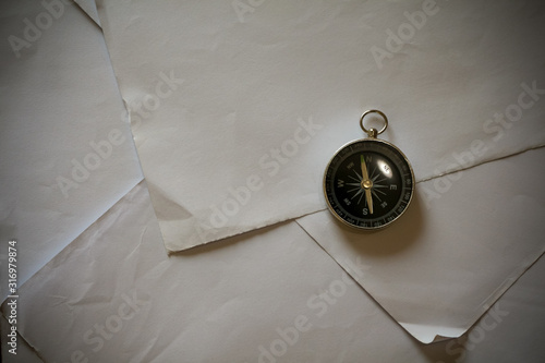 vintage compass resting on scattered papers