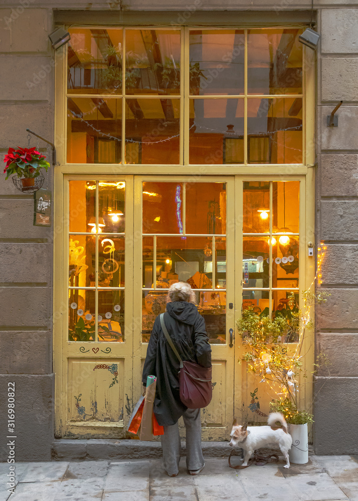 Mujer ante un escaparate antiguo del Barrio Gótico Mujer ante un escaparate antiguo del Barrio Gótico