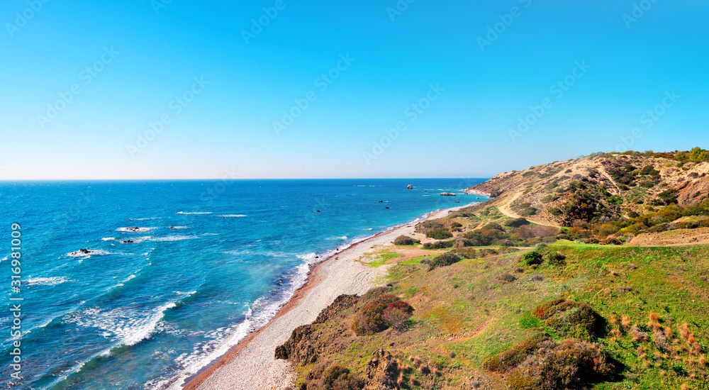 Seashore and pebble beach with wild coastline in Cyprus island, Greece by Petra tou Romiou sea rocks