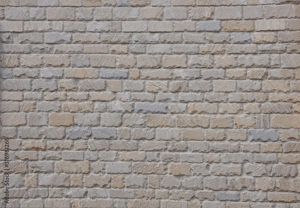 An example of ancient masonry as a cladding of external walls of castle. Natural stone background.  Beige stone wall texture with torn edges