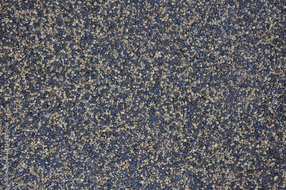 Texture of small multi-colored natural stone - river pebbles of gray and beige colors. sidewalk background. decorative coating for construction - wall and floor finishes in interiors Texture of small multi-colored natural stone - river pebbles of gray and beige colors. sidewalk background. decorative coating for construction - wall and floor finishes in interiors