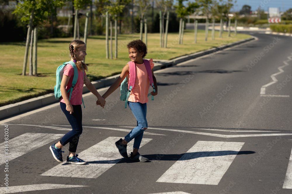 Two schoolgirls crossing the road on a pedestrian crossing Stock Photo ...