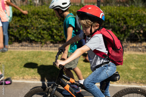Schoolboy wearing a cycling helmet and riding a bicycle