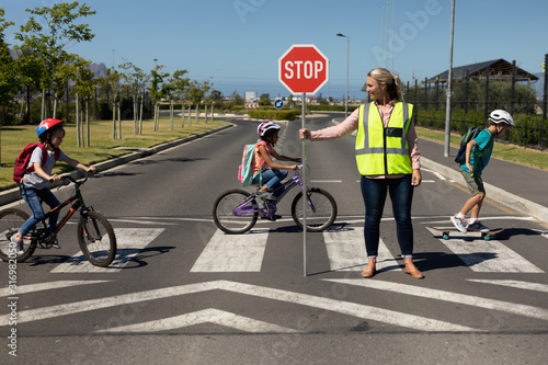 Woman wearing a high visibility vest and holding a stop sign