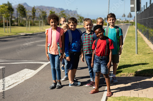 Schoolchildren waiting at a pedestrian crossing to cross the road